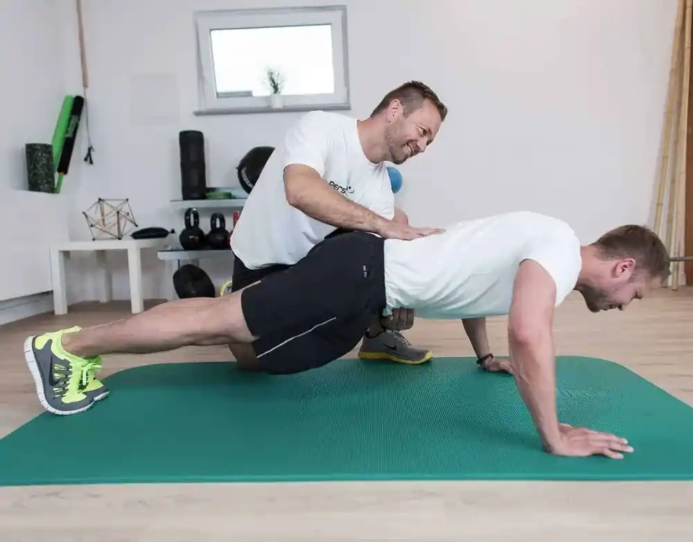 Trainer korrigiert Haltung beim Sport